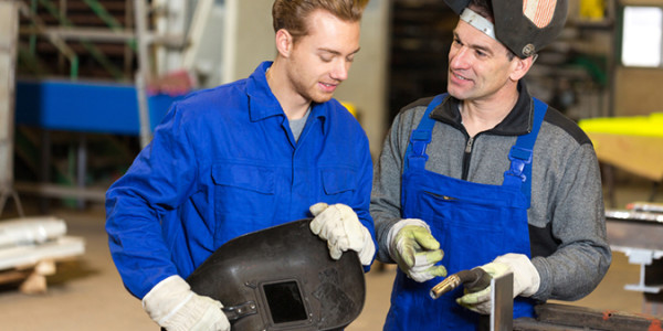 two guys in blue work suits wearing white gloves